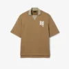 Polo oversize de satén con detalle de insignia de pasarela