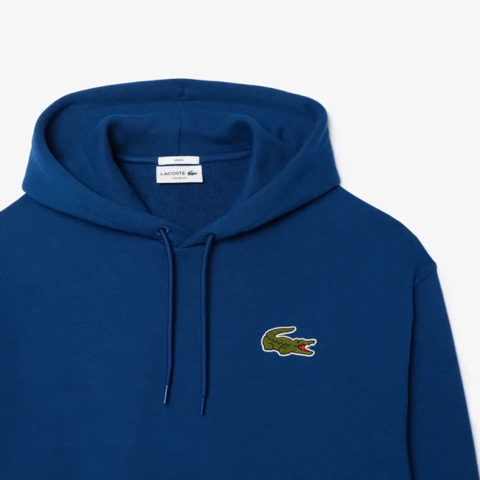 Sudadera con capucha unisex de corte holgado y detalle de insignia