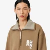 Sudadera con cuello alto, cremallera y detalle de insignia de la pasarela