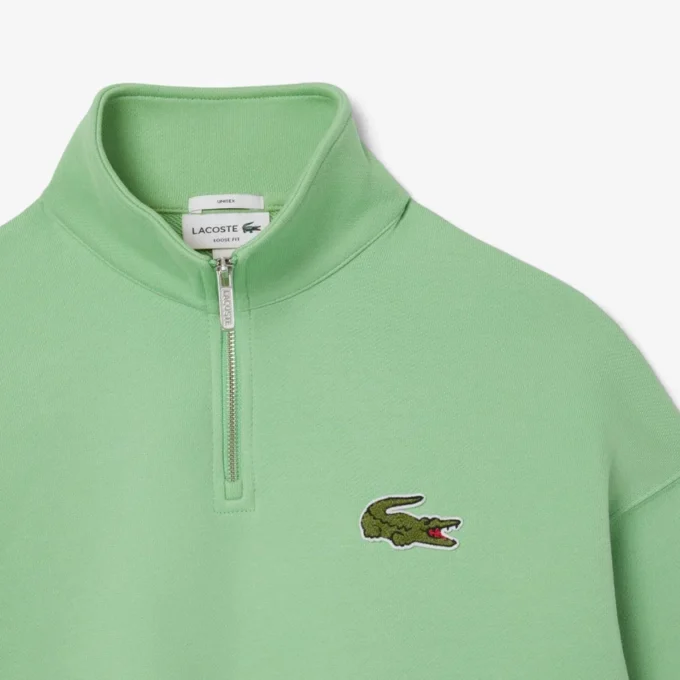 Sudadera unisex de corte holgado con detalle de insignia y media cremallera